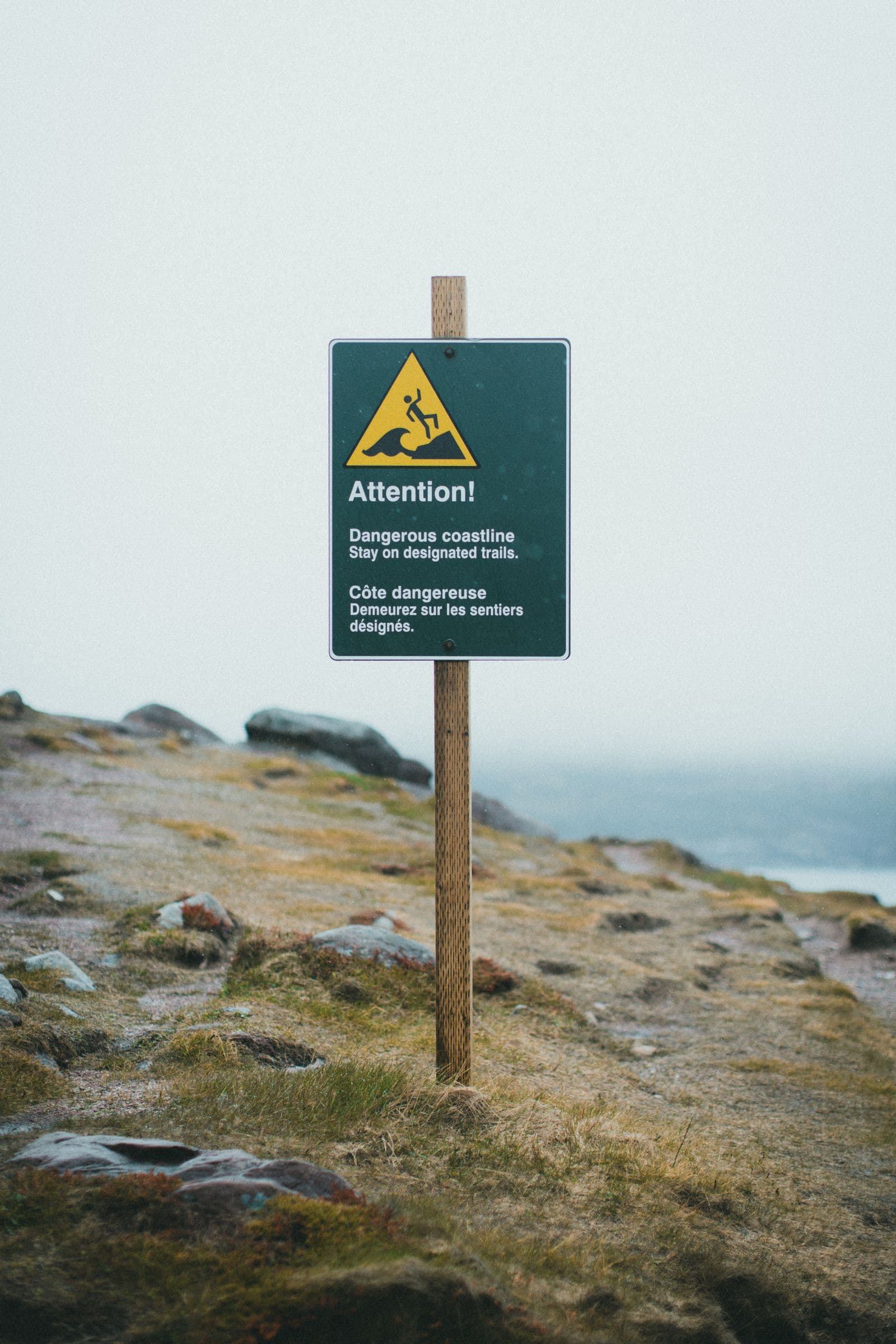 Advarselsskilt på en klippekant i tåget vejr