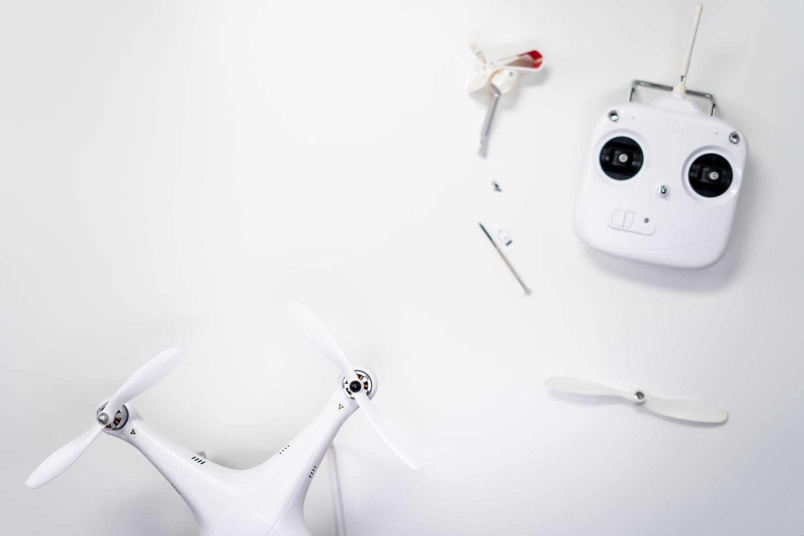 Dronesæt med fjernbetjening og ekstra propeller lagt frem