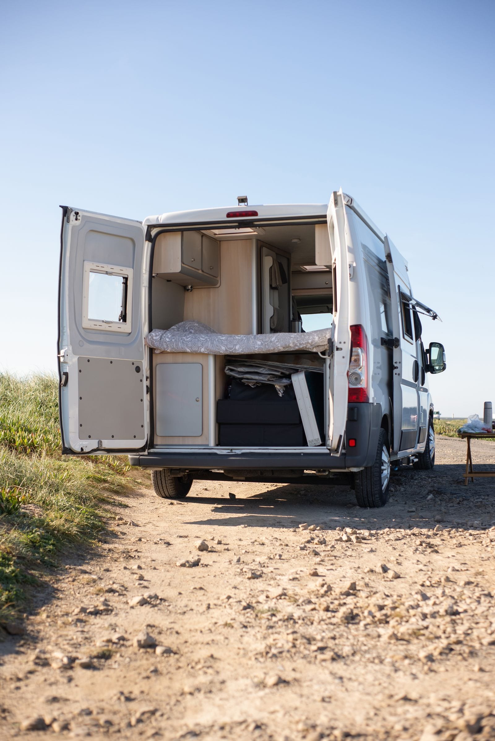 Rummelig autocamper på landevej i sommerlandskab