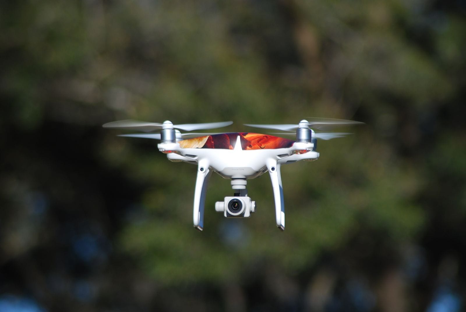 Drone med kamera svævende foran sløret natur