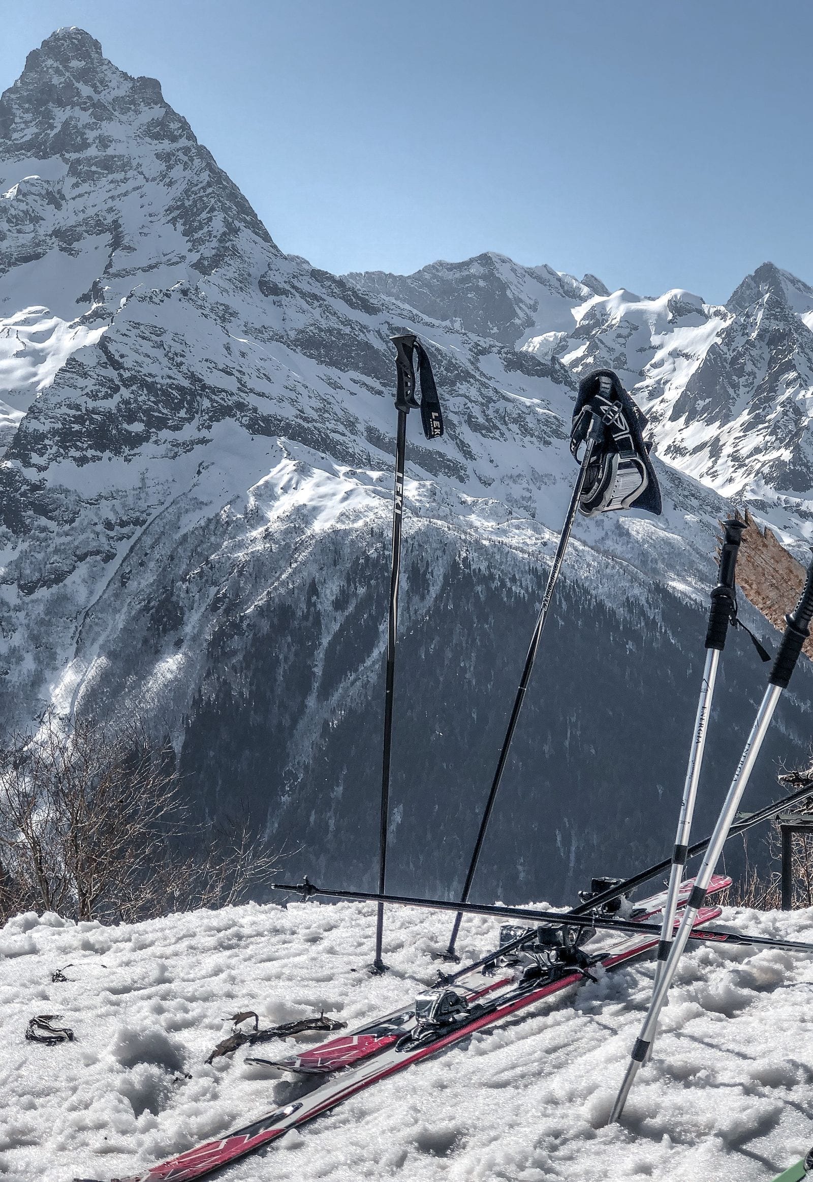 Ski og stave på en snedækket bjergside